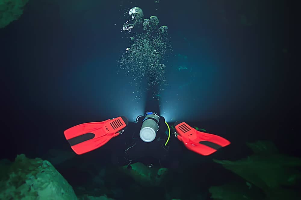 Diver in the dark with bright scuba diving fins