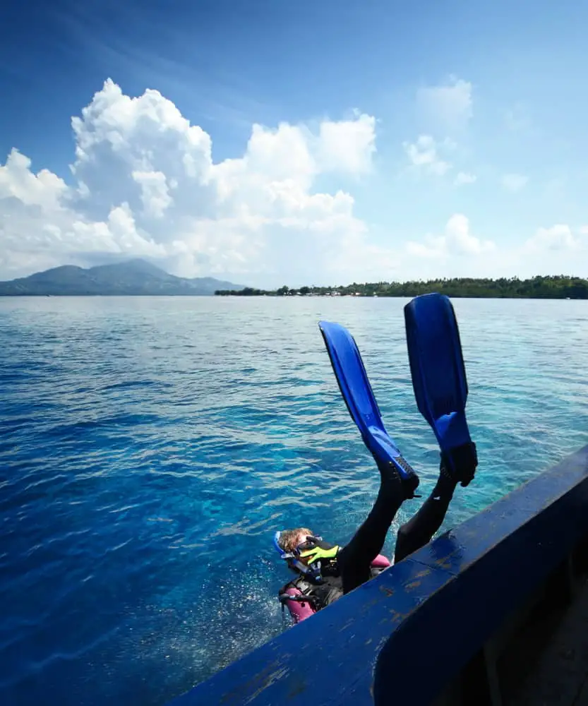 Scuba diver rolling back first into the water