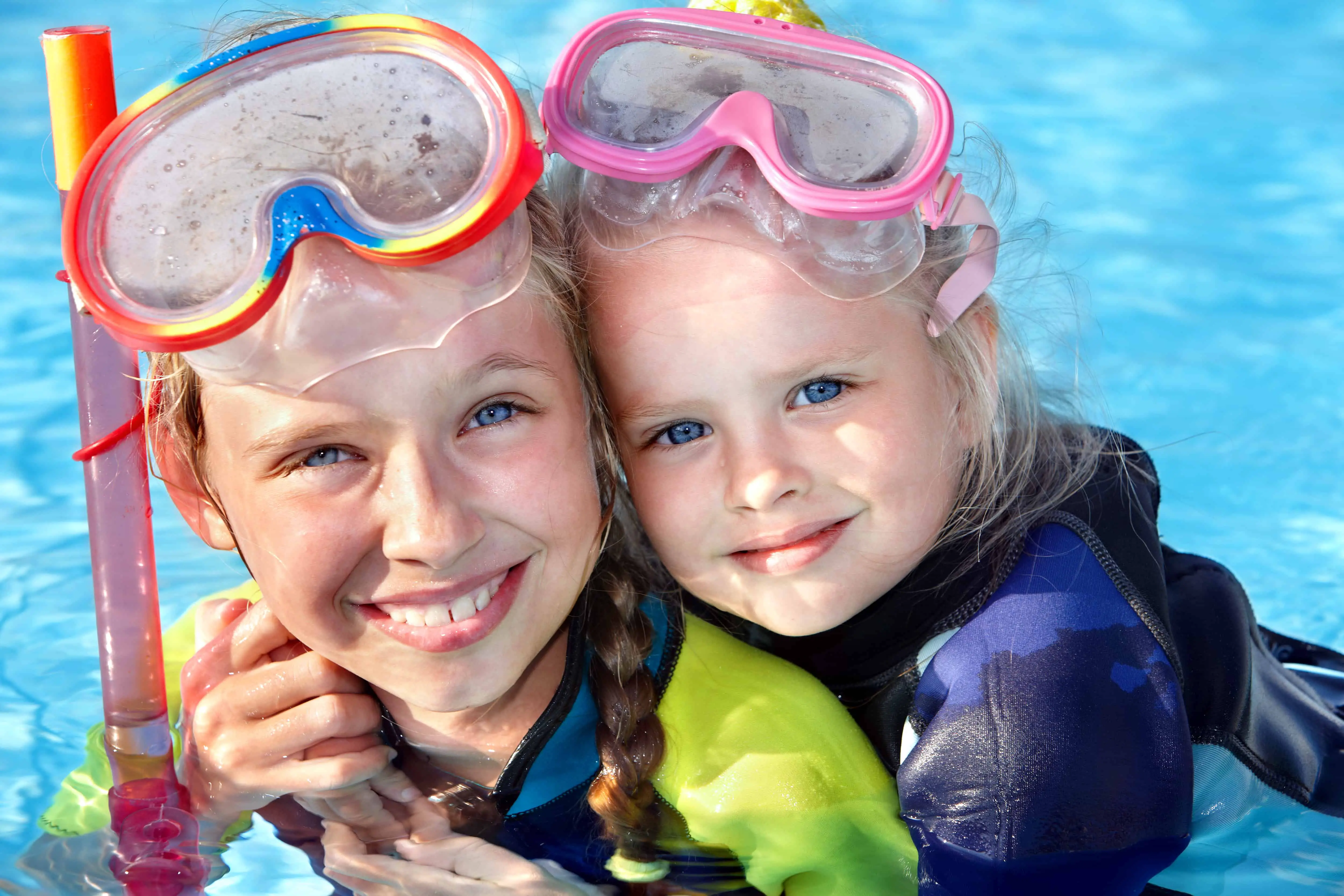 Children in swimming pool learning snorkeling.