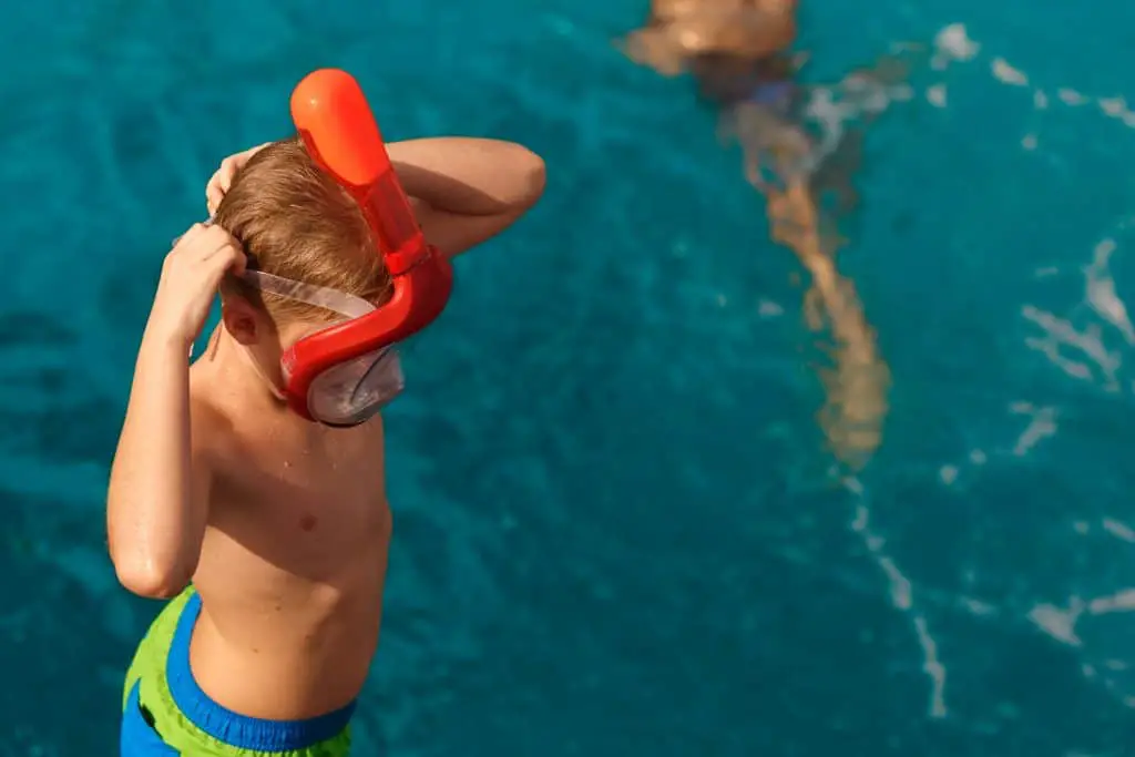 Child Putting on a whole face snorkel goggles