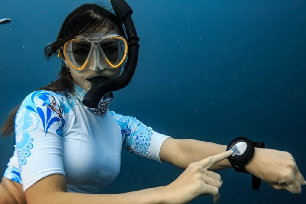 Diver pointing at her working dive computer